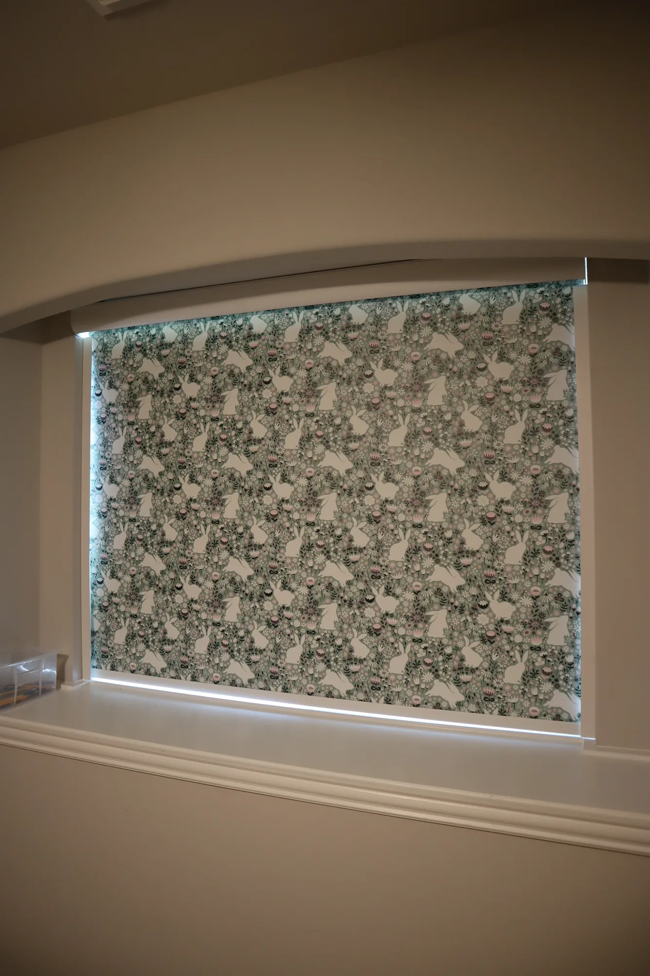 A patterned roller shade on a single dining room window