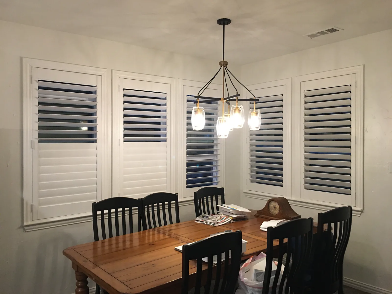 White plantation shutters on three dining room windows