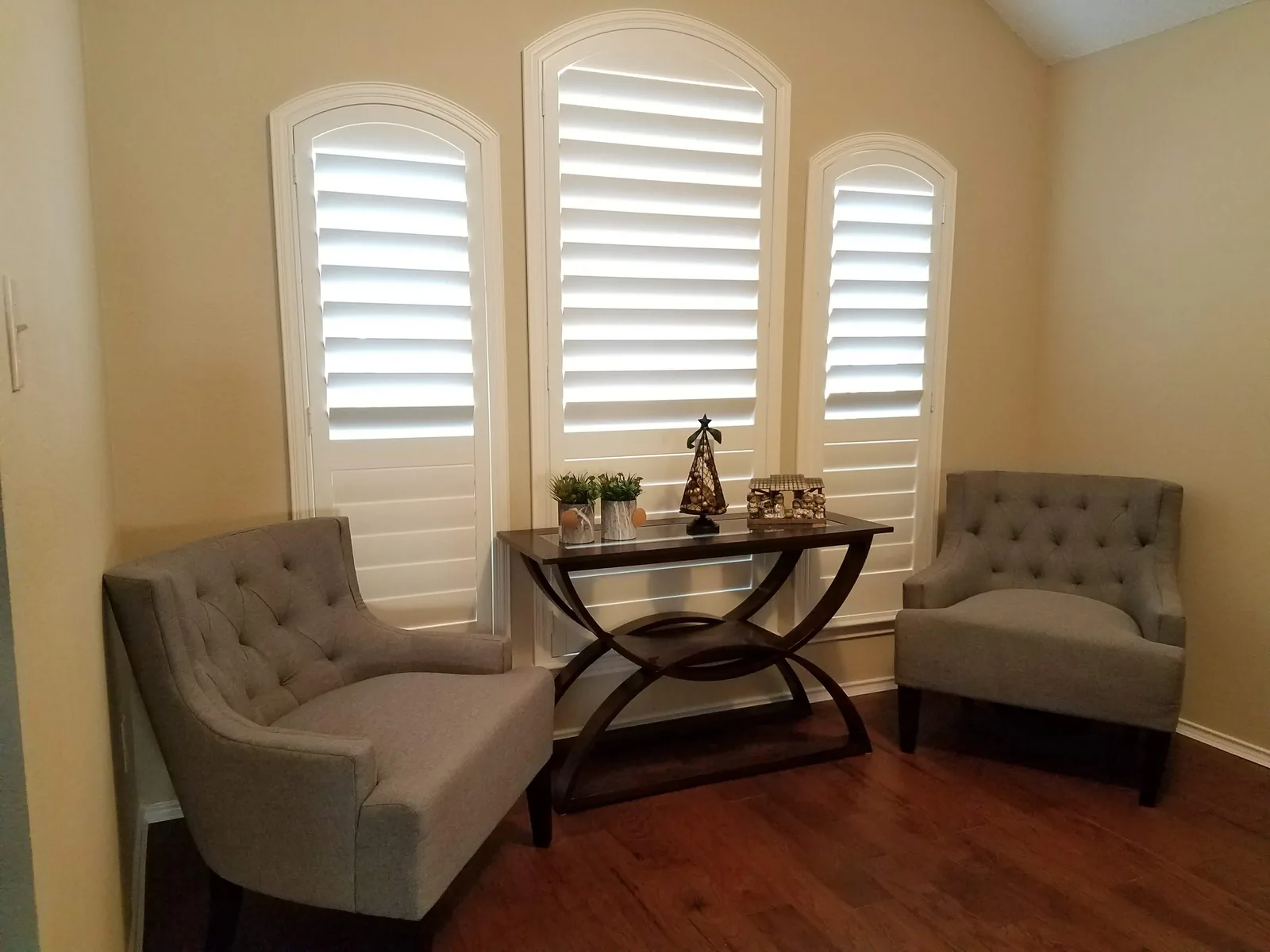 Plantation shutters behind two armchairs in a sitting room