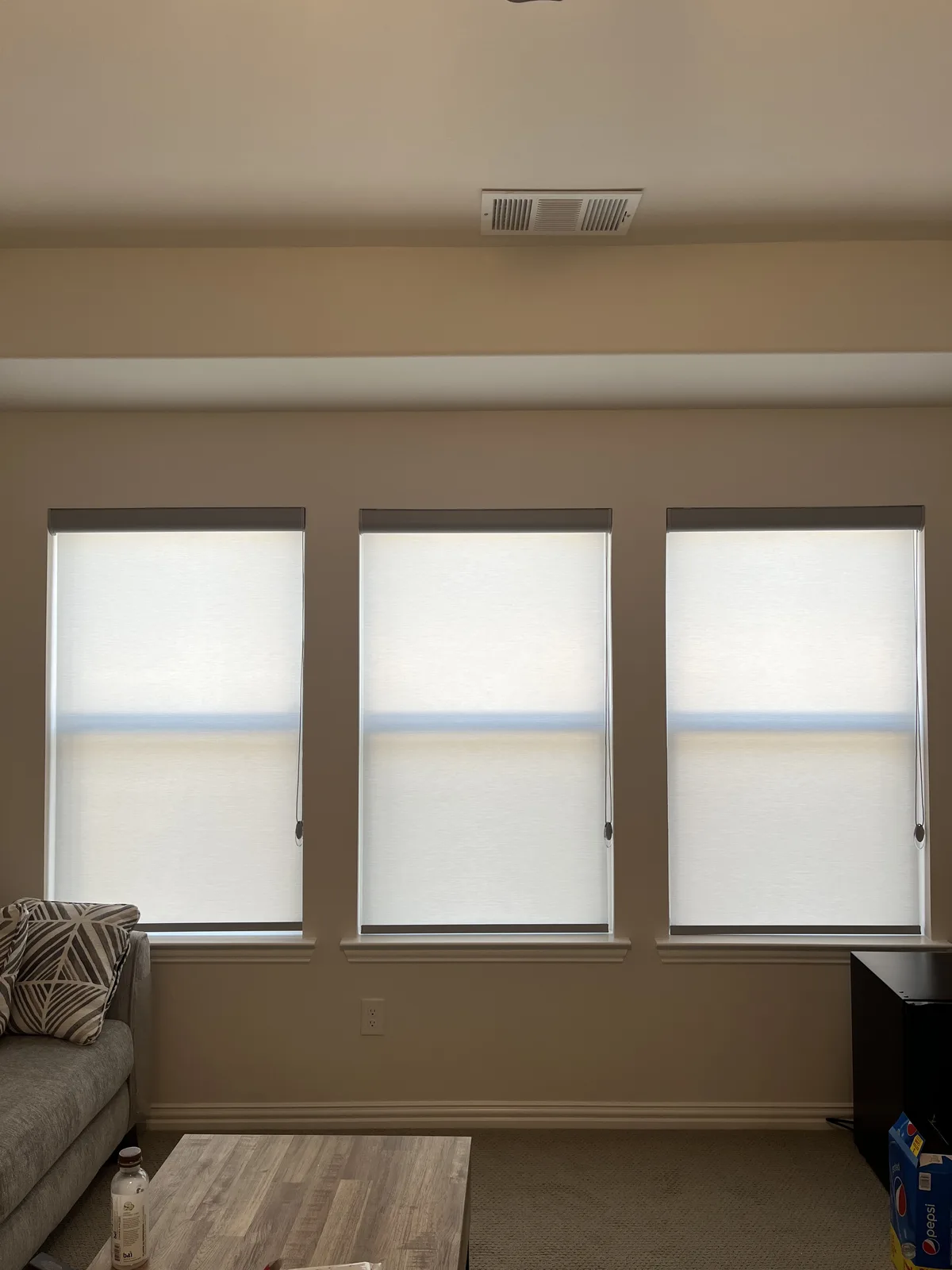 Light-filtering roller shades on three tall living room windows