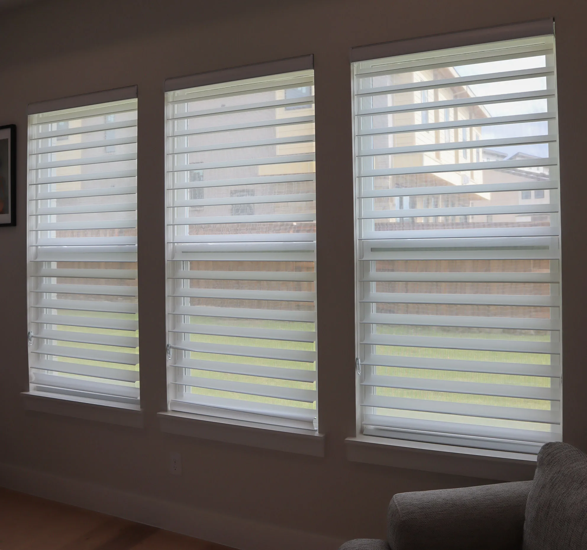 Triple shades with the vanes open on three windows
