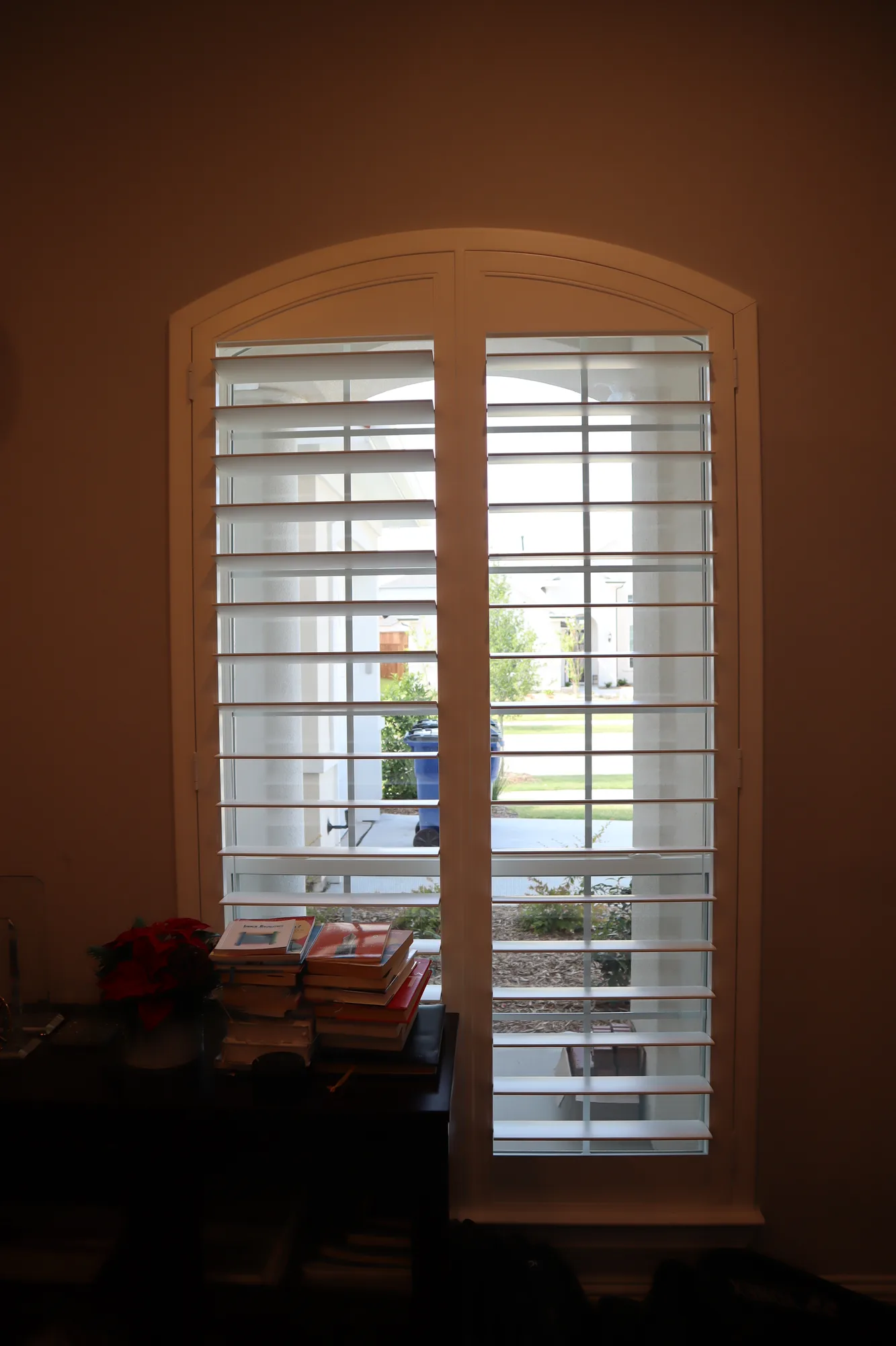 White plantation shutters on an arched French door