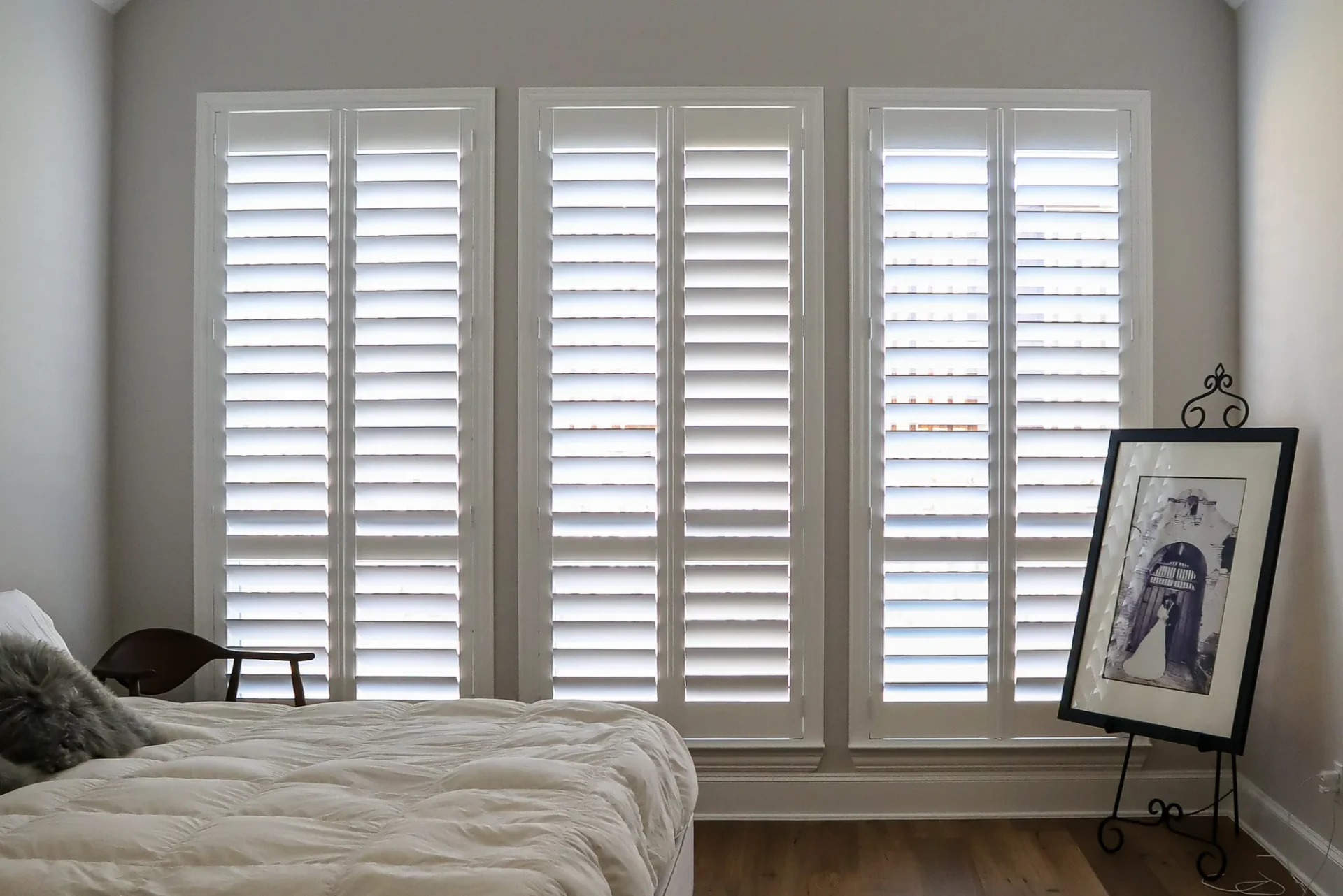 White plantation shutters on three primary bedroom windows