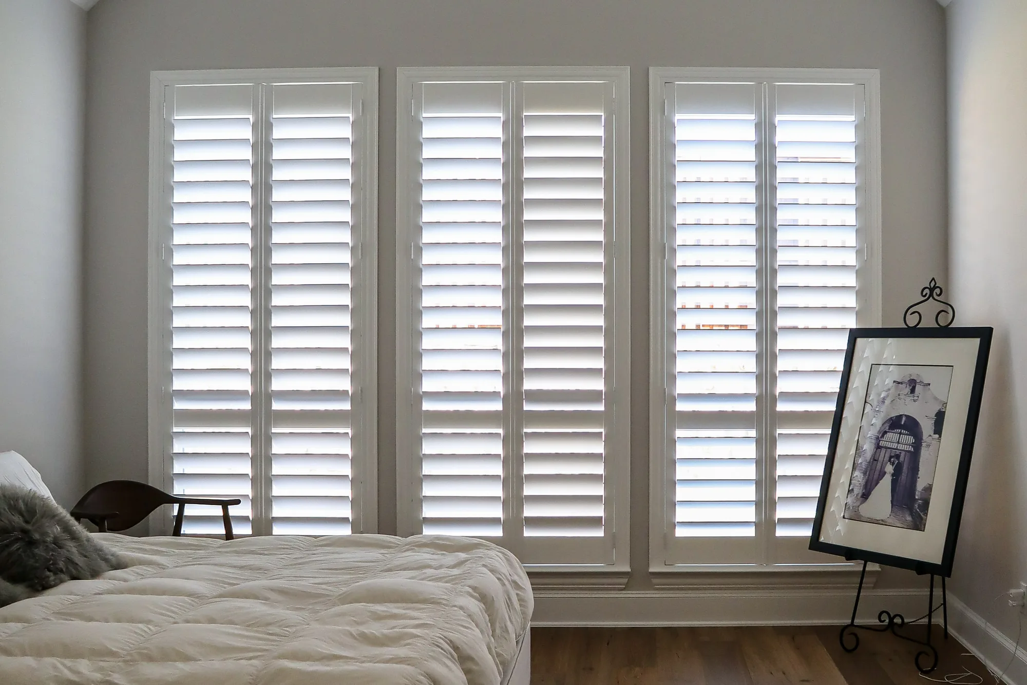 White plantation shutters on three primary bedroom windows