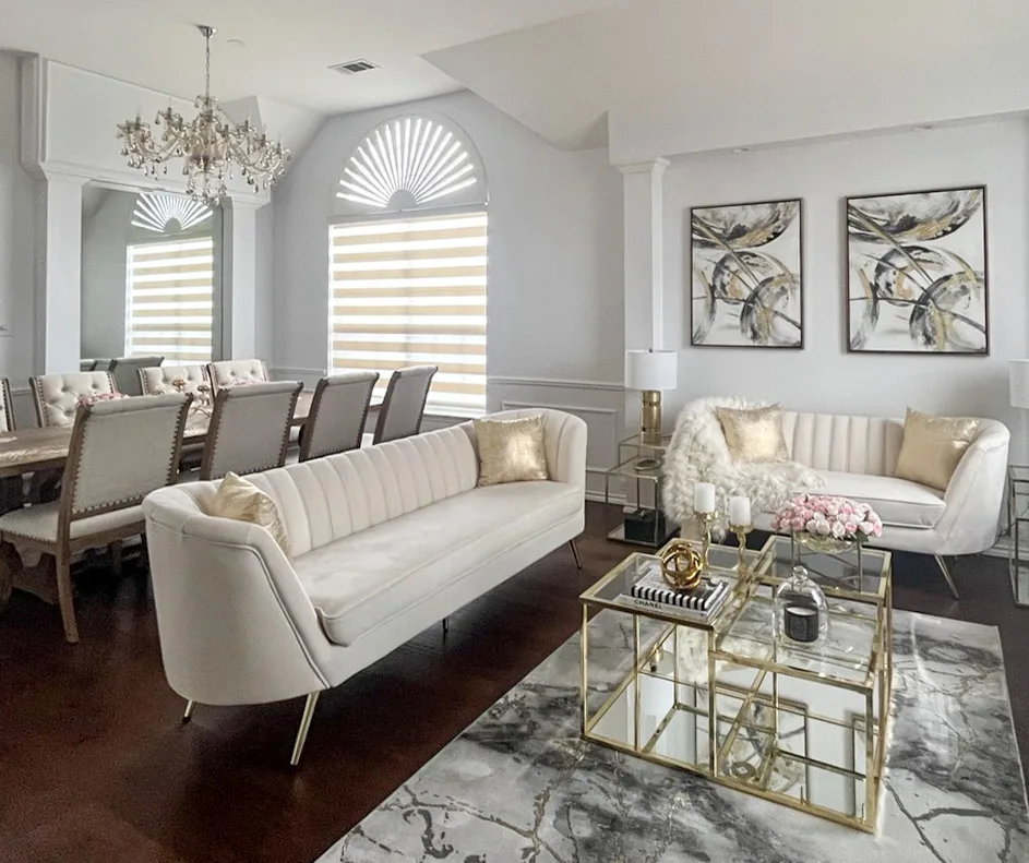 Zebra shades on living room windows below an arched transom